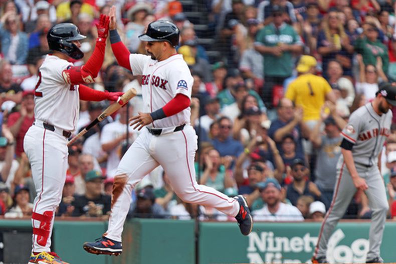 El corredor de los Medias Rojas de Boston, Mickey Gasper (centro), choca los cinco con su compañero Wilyer Abreu (izquierda) después de anotar en la cuarta entrada de un partido de béisbol contra los Gigantes de San Francisco, el domingo 23 de agosto de 2026, en Boston. (Foto AP/Jim Davis)