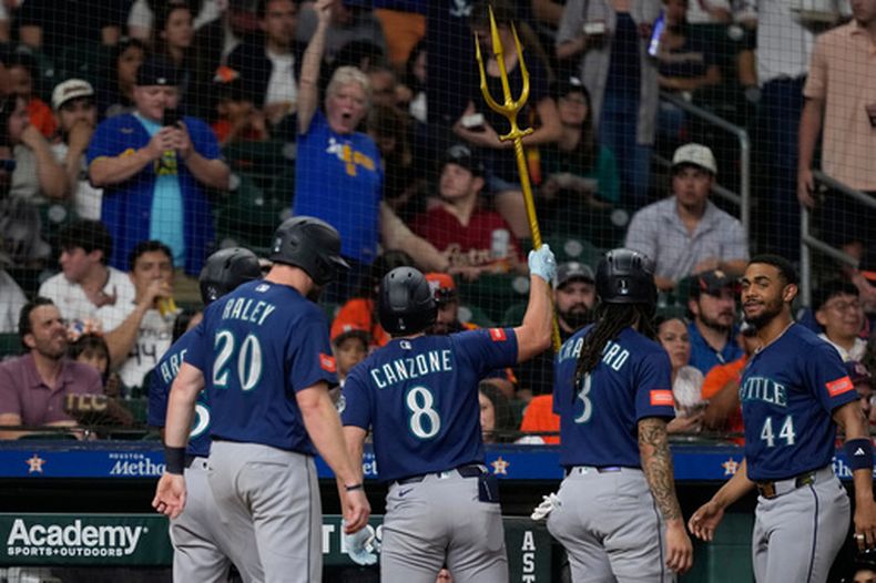 Dominic Canzone (8), de los Marineros de Seattle, celebra tras conectar un grand slam contra los Astros de Houston durante la cuarta entrada de un partido de béisbol, el martes 12 de mayo de 2026, en Houston. (Foto AP/David J. Phillip)