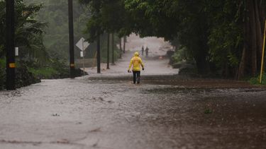 El capitán Lui Sales, del Departamento de Bomberos de Hawai, busca gente para ayudar mientras el agua de lluvia causada por el huracán Nolo inunda un tramo de la autopista Mamalahoa, Hawai, el sábado 26 de septiembre de 2026. (Foto AP/Gregory Bull)