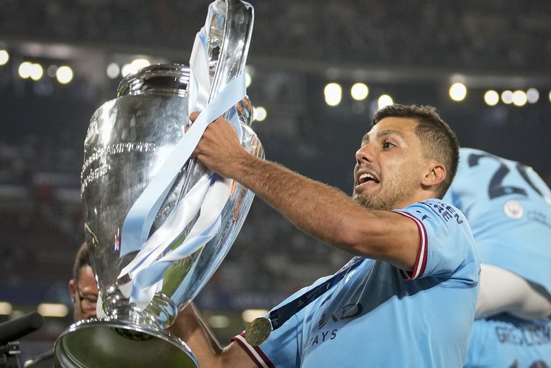 El volante español Rodrigo del Manchester City alza el trofeo de la Liga de Campeones tras la victoria 1-0 ante el Inter de Milán en la final, el sábado 11 de junio de 2023, en Estambul. (AP Foto/Emrah Gurel)