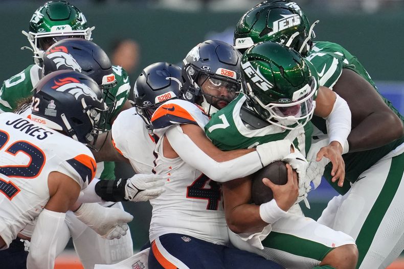 El quarterback de los Jets de Nueva York Justin Fields tacleado por la defensa de los Broncos de Denver en el juego de la NFL en Londres el domingo 12 de octubre del 2025.(AP Foto/Kin Cheung)