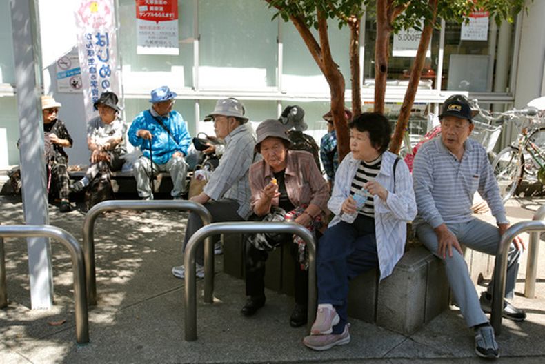 Varias personas mayores descansan a la sombra de un árbol en Tokio, el 14 de septiembre de 2014. (AP Foto/Shizuo Kambayashi, archivo)