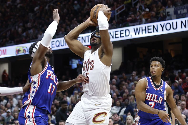 Donovan Mitchell, de los Cavaliers de Cleveland, dispara frente a Buddy Hield, de los 76ers de Filadelfia, en el encuentro del viernes 29 de marzo de 2024 (AP Foto/Ron Schwane)