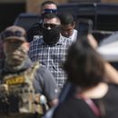 Agentes federales escoltan a un hombre a un autobús después de ser detenido después de una comparecencia en la corte de inmigración, el lunes 28 de julio de 2025, en San Antonio. (AP Foto/Eric Gay)