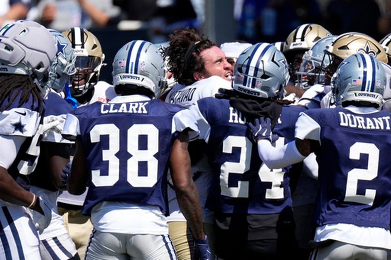 El tight end Moliki Matavao (centro) de los Saints de Nueva Orleans durante un forcejeo con jugadores de los Cowboys de Dallas, el martes 18 de agosto de 2026, en Oxnard, California. (AP Foto/Mark J. Terrill)