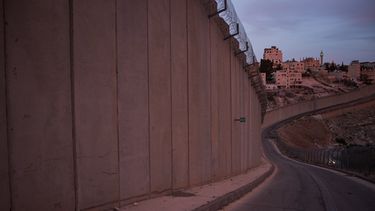 El minarete de una mezquita y varios edificios de la localidad cisjordana de Abu Dis, vistos desde detrás del muro de separación construido por Israel cerca de Jerusalén, el 5 de octubre de 2026. (AP Foto/Leo Correa)