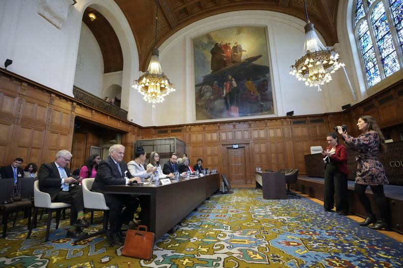 La delegación de Colombia, izquierda, espera la llegada de los jueces de la Corte Internacional de Justicia, en la Haya, Holanda, el jueves 13 de julio de 2023. (AP Foto/Peter Dejong)