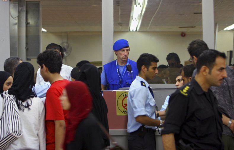 ARCHIVO - Un observador de la Unión Europea ve a palestinos pasar de Egipto hacia la Franja de Gaza el martes 18 de julio de 2006, en el cruce fronterizo de la ciudad de Rafah. (AP Foto/ Khalil Hamra, archivo)