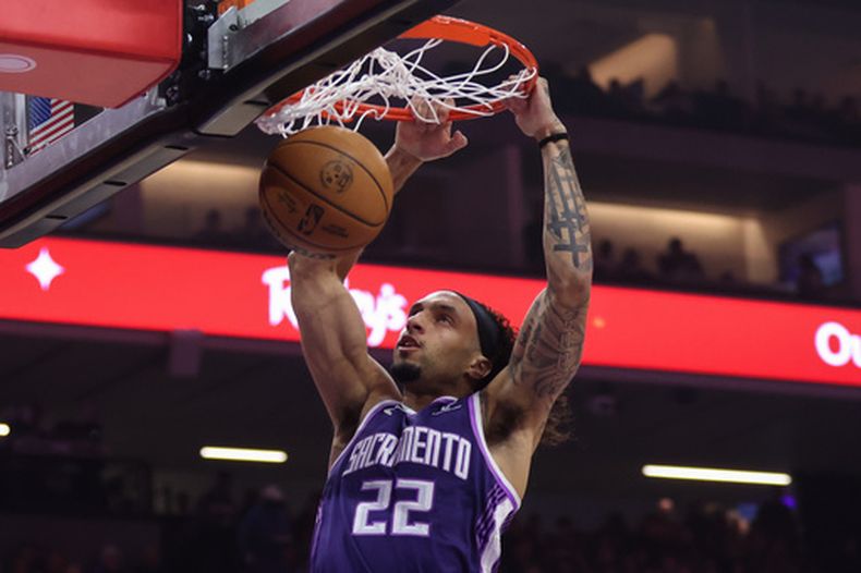 Devin Carter, de los Kings de Sacramento, realiza una clavada ante los Warriors de Golden State, el viernes 10 de abril de 2026 (AP Foto/Scott Marshall)