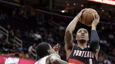 americateve | Damian Lillard, de los Trail Blazers de Portland, salta para disparar frente a Kyrie Irving, de los Cavaliers de Cleveland, el martes 17 de diciembre de 2013 (AP Foto/Tony Dejak)
