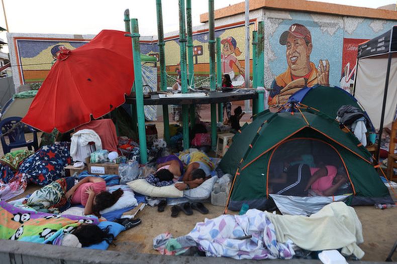 Personas cuyas casas resultaron dañadas por los terremotos duermen a la intemperie frente a un estadio de béisbol en Catia La Mar, Venezuela, el domingo 28 de junio de 2026. (Foto AP/Pedro Mattey)