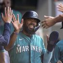 Teoscar Hernandez felicitado por sus compañeros de los Marineros de Seattle en el dugout tras anotar con el sencillo de Jarred Kelenic en el encuentro ante los Rays de Tampa Bay el sábado 1 de julio del 2023. (AP Foto/Stephen Brashear)