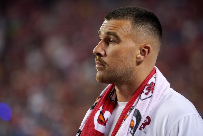 Travis Kelce, tight end de los Chiefs de Kansas City, observa desde la línea de banda el encuentro inaugural de la campaña ante los Lions de Detroit, el jueves 7 de septiembre de 2023 (AP Foto/Ed Zurga)