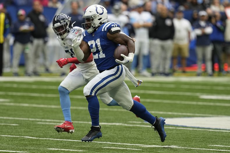 Zack Moss, derecha, corredor de los Colts de Indianápolis, se escapa para un touchdown de 65 yardas superando al safety Kevin Byard (31), de los Titans de Tennessee, durante la primera mitad del juego de la NFL, el domingo 8 de octubre de 2023, en Indianápolis. (AP Foto/Darron Cummings)