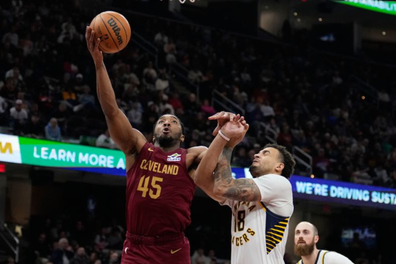 Donovan Mitchell (45), de los Cavaliers de Cleveland, se alista para embocar una canasta al lado de Jalen Slawson (18), de los Pacers de Indiana, en la segunda mitad del juego de baloncesto de la NBA, el domingo 5 de abril de 2026, en Cleveland. (AP Foto/Sue Ogrocki)