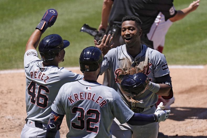 Justyn-Henry Malloy, derecha, de los Tigres de Detroit, celebra con Wenceel Pérez (46) y Ryan Kreidler (32) después de conseguir un jonrón de campo, en el que también anotó Pérez, durante la cuarta entrada del juego de béisbol en contra de los Angelinos de Los Ángeles el domingo 30 de junio de 2024, en Anaheim, California. (AP Foto/Mark J. Terrill)