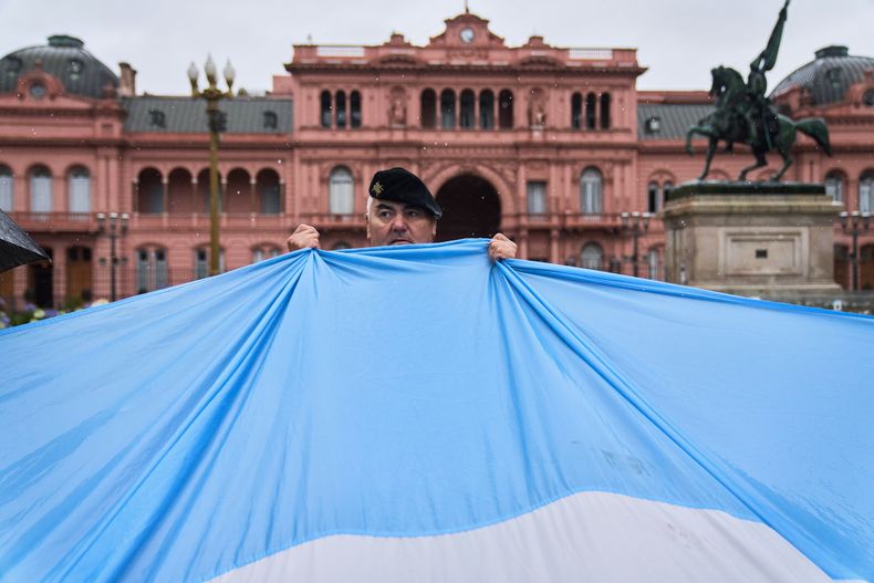 Un militar retirado sostiene una bandera argentina frente al palacio presidencial durante una protesta en Buenos Aires, Argentina, el sábado 29 de noviembre de 2025, para exigir la liberación de exmilitares acusados de violaciones a los derechos humanos durante la última dictadura. (AP Foto/Rodrigo Abd)
