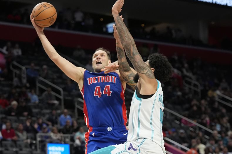 Bojan Bogdanovic (44), alero de los Pistons de Detroit, logra un enceste ante la presión Nick Richards (4), de los Hornets de Charlotte, durante la segunda mitad del juego de baloncesto de la NBA, el miércoles 24 de enero de 2024, en Detroit. (AP Foto/Carlos Osorio)