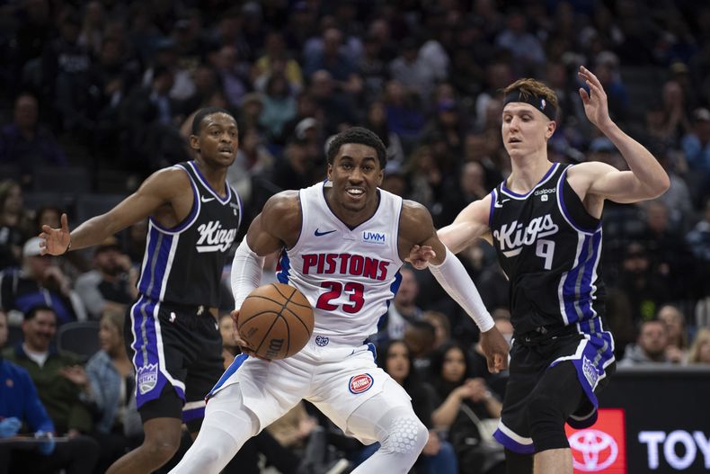 Jaden Ivey, de los Pistons de Detroit, intenta avanzar frente a Kevin Huerter (derecha) y DeAaron Fox, de los Kings de Sacramento, durante el partido del miércoles 7 de febrero de 2024 (AP Foto/José Luis Villegas)