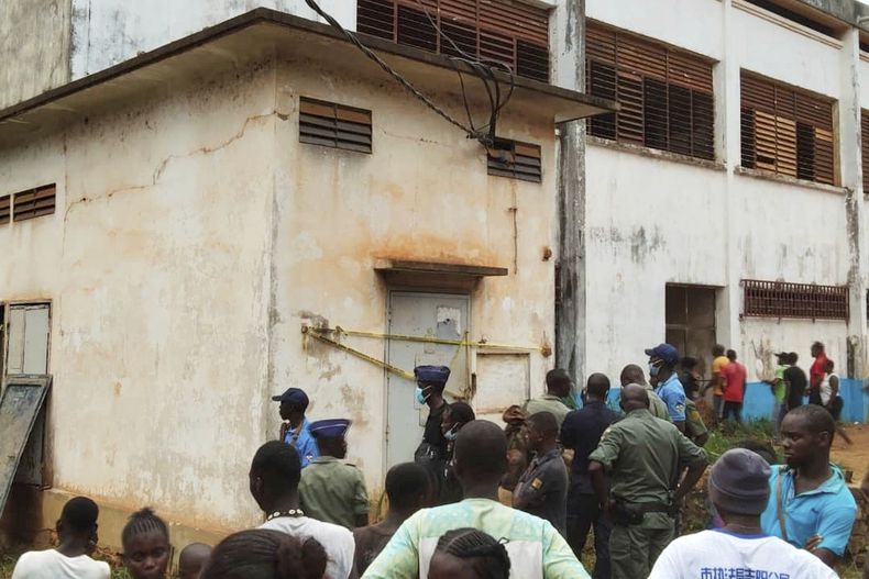 Un grupo de personas se congrega en el lugar donde se registró una explosión que provocó una estampida, incidentes en que murieron decenas de estudiantes y cientos de ellos resultaron heridos, en una escuela secundaria en Bangui, la capital de la República Centroafricana, el jueves 26 de junio de 2025. (AP Foto/Jean Fernand Koena)