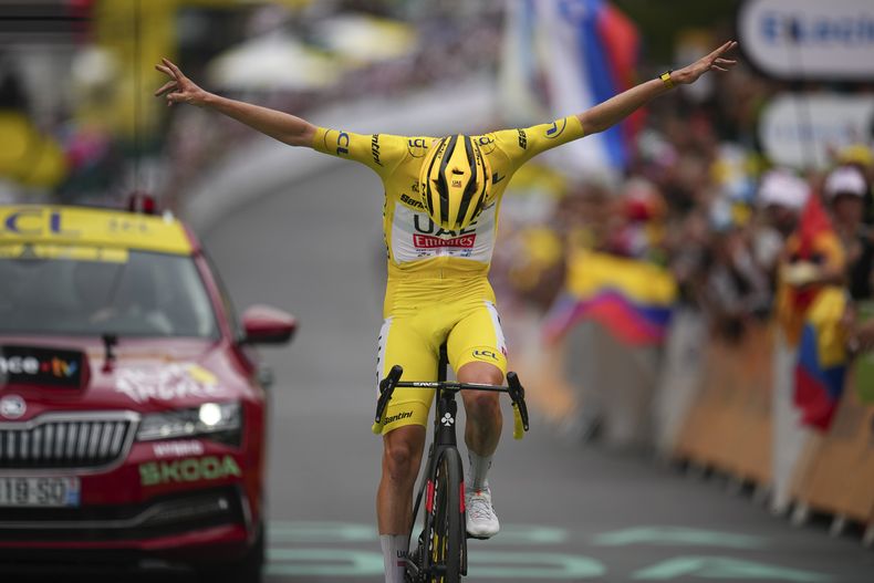 El esloveno Tadej Pogacar, portando el maillot amarillo de líder general, cruza la meta con los brazos en alto y con una reverencia al ganar la 19ma etapa del Tour de Francia entre Embrun e Isola 2000 el viernes 19 de julio del 2024. (AP Foto/Daniel Cole)