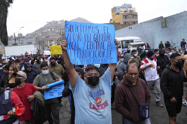 Un manifestante porta un cartel contra la migración venezolana en una marcha en el distrito limeño de La Victoria, Perú, el jueves 9 de noviembre de 2023. El gobierno puso como fecha límite el 10 de noviembre para que los venezolanos que viven en Perú soliciten la residencia temporal. (AP Foto/Martín Mejía)