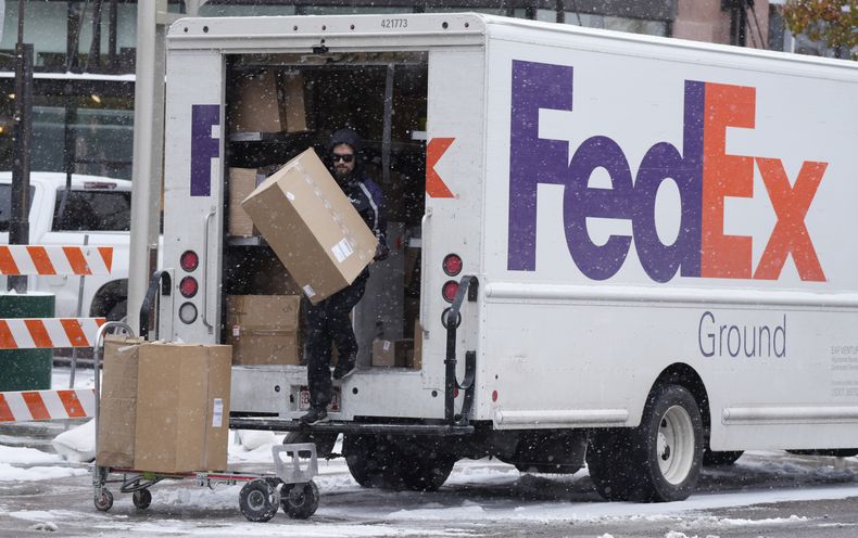 Un trabajador de FedEx entrega varios paquetes, en Denver, el 17 de noviembre de 2022. (AP Foto/David Zalubowski, Archivo)