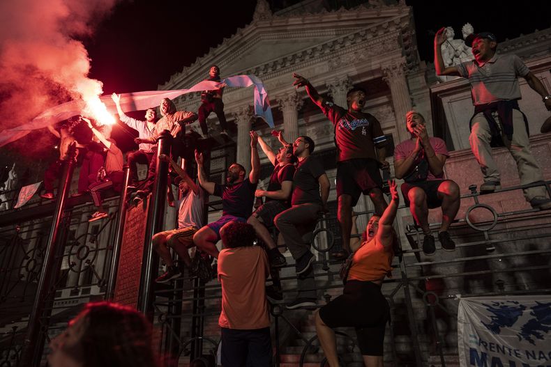 ARCHIVO - Manifestantes corean consignas antigubernamentales en las rejas que protegen el Congreso Nacional durante una protesta contra las medidas económicas del gobierno en Buenos Aires, Argentina, el 21 de diciembre de 2023. (AP Foto/Rodrigo Abd, Archivo)