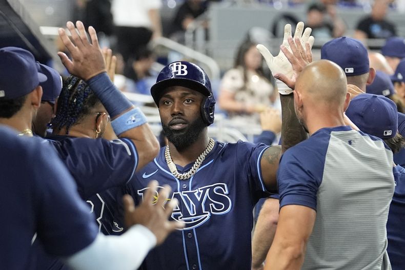 Randy Arozarena, de los Rays de Tampa Bay, es felicitado en el dugout después de anotar carrera con un doble de Isaac Paredes durante la primera entrada del juego de béisbol en contra de los Marlins de Miami, el miércoles 5 de junio de 2024, en Miami. (AP Foto/Lynne Sladky)