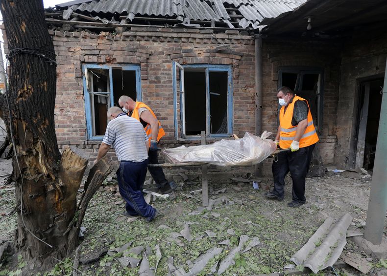Rescatistas cargan el cuerpo de una mujer que muri&oacute; durante un bombardeo en Donetsk, en el oriente de Ucrania el martes 5 de agosto de 2014. La ONU se&ntilde;al&oacute; que que la situaci&oacute;n humanitaria en el oriente de Ucrania empeora. (Foto