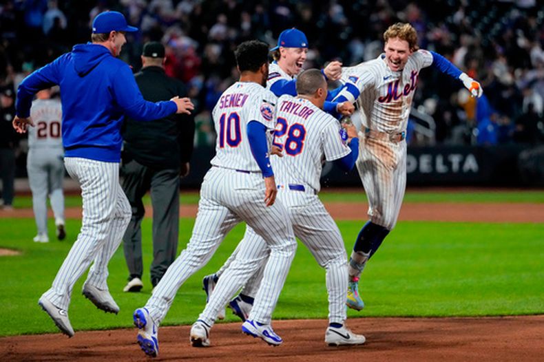 Carson Benge (3), derecha, de los Mets de Nueva York, celebra con sus compañeros de equipo después de conectar un sencillo para dejar tendidos en el campo a los Tigres de Detroit en juego de béisbol de Grandes Ligas, el miércoles 13 de mayo de 2026, en Nueva York. (AP Foto/Yuki Iwamura)
