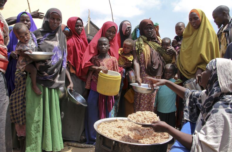 Somalíes desplazados reciben comida en un campamento en Tabelaha, en las afueras de Mogadiscio, Somalia, el 30 de marzo del 2017. (AP foto/Farah Abdi Warsameh)