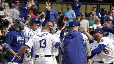 Max Muncy, de los Dodgers de Los Ángeles, es felicitado por sus compañeros tras conectar un grand slam que significó la victoria sobre los Filis de Filadelfia, el miércoles 3 de mayo de 2023 (AP Foto/Mark J. Terrill)