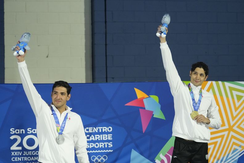 Miguel de Lara (derecha) y Andrés Puente, posan respectivamente con el oro y la plata que consiguieron para México en los 100 metros pecho de natación, el domingo 25 de junio de 2023, en los Juegos Centroamericanos y del Caribe de San Salvador (AP Foto/Arnulfo Franco)