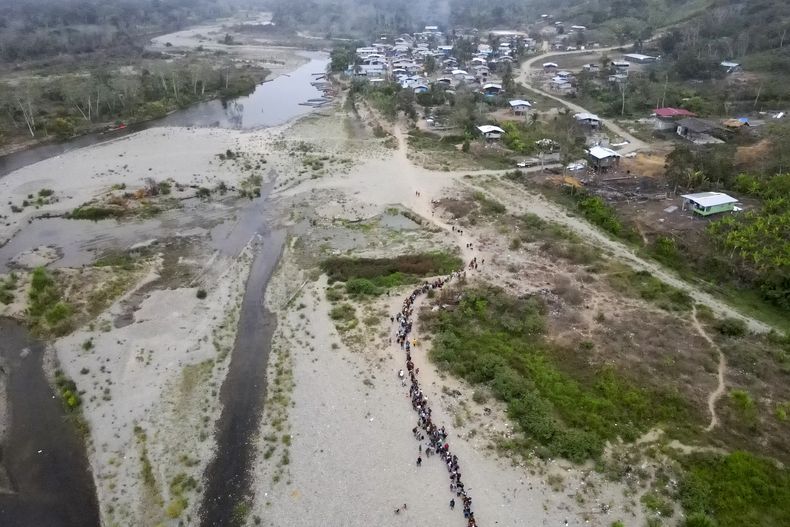Migrantes hacen fila para tomar un bote hacia Lajas Blancas en Bajo Chiquito, en la provincia de Darién, Panamá, el domingo 7 de mayo de 2023. Miles de migrantes que atraviesan el Tapón del Darién desde Colombia salen de la jungla por Bajo Chiquito. La policía de fronteras panameña informó el miércoles 31 de mayo de 2023 de la muerte de tres sujetos armados que se dedicaban presuntamente a robar a los migrantes en enfrentamiento con uniformados. (AP Foto/Natacha Pisarenko)