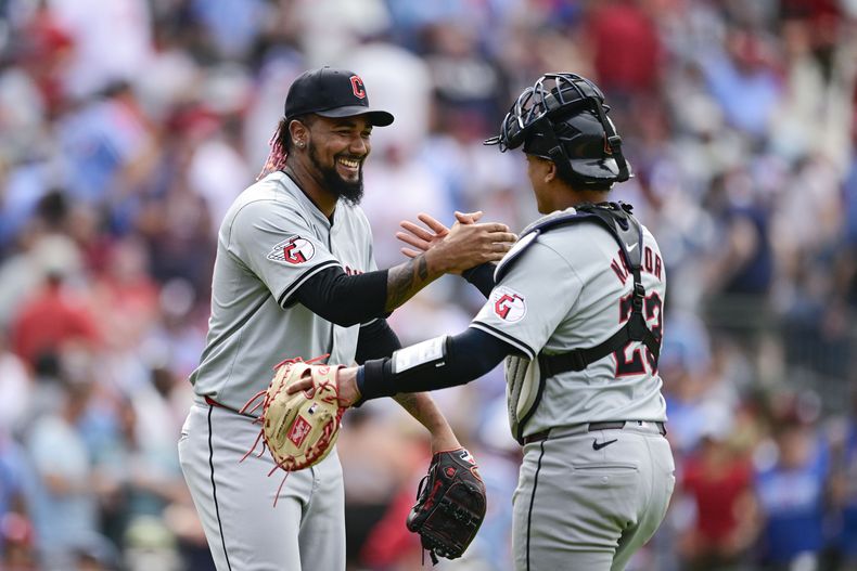 El dominicano de los Guardianes de Cleveland, Emmanuel Clase (izquierda) y Bo Naylor (derecha) celebran luego del último out del juego de béisbol ante los Filis de Filadelfia, el domingo 28 de julio de 2024, en Filadelfia. (AP Foto/Derik Hamilton)