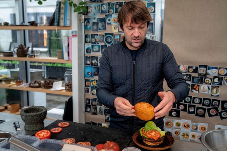 El chef de Noma René Redzepi prepara una hamburguesa vegetariana en un restaurante en Copenhague, el 24 de noviembre de 2024. (Soeren Bidstrup/Ritzau Scanpix via AP)