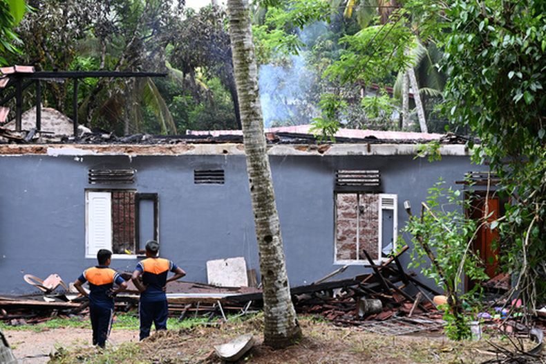 Soldados de Sri Lankan se ven ante los restos de una casa para ancianos calcinada en Anguruwatota, Sri Lanka, el jueves 4 de junio de 2026.(AP Foto)