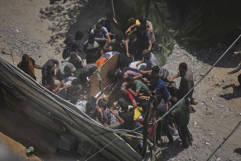 Palestinos tratan de conseguir ayuda humanitaria lanzada por aire en paracaídas sobre la Ciudad de Gaza, en el norte de la Franja de Gaza, el 7 de agosto de 2025. (AP Foto/Jehad Alshrafi)