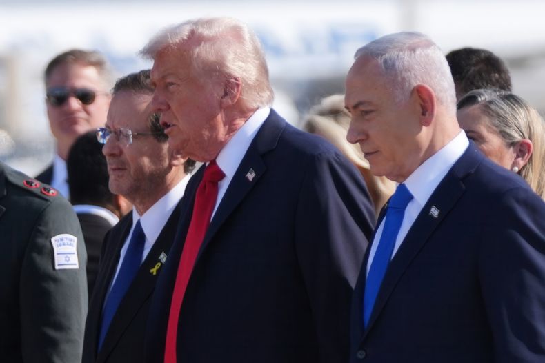 El presidente de Estado Unidos, Donald Trump, camina con el presidente de Israel, Isaac Herzog, a la izquierda, y el primer ministro de Israel, Benjamin Netanyahu, en una ceremonia de bienvenida en el aeropuerto Ben Gurion, el lunes 13 de octubre de 2025, cerca de Tel Aviv. (AP Foto/Evan Vucci)