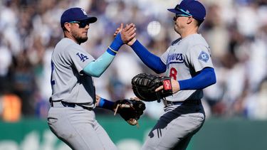 El tercera base de los Dodgers de Los Ángeles Miguel Rojas celebra con el primera base Enrique Hernández tras la victoria ante los Gigantes de San Francisco el sábado 26 de septiembre del 2026. (AP Foto/Jeff Chiu)