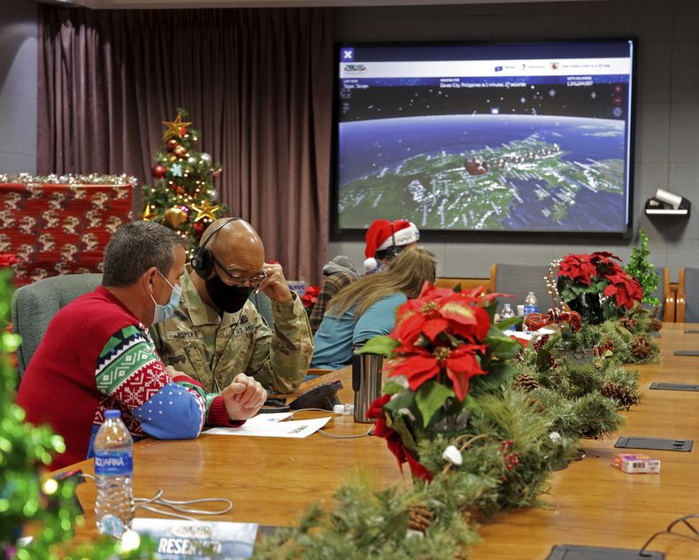 Esta imagen distribuida por el Departamento de Defensa muestra a voluntarios mientras toman llamadas y responden a emails de niños de todo el mundo durante el evento anual del Comando de Defensa Aeroespacial de Norteamérica (NORAD) para seguir los pasos de Santa Claus, el 24 de diciembre de 2021, en la Base Aérea Peterson, en Colorado Springs, Colorado. (Chuck Marsh/Department of Defense via AP)