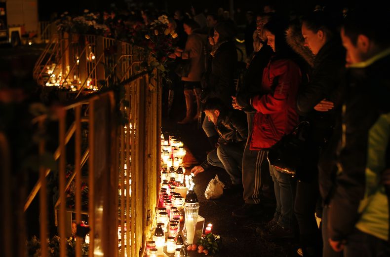 Cientos de letones colocan veladoras y flores frente al supermercado Maxima en Riga, el viernes 22 de noviembre de 2013 luego que decenas de personas murieron, entre ellas tres bomberos, en el derrumbe de una enorme parte del techo del supermercado en la