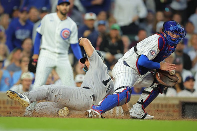 Spencer Jones, de los Yankees de Nueva York, se desliza hacia el plato tras un sencillo productor de carreras de José Caballero, también de los Yankees de Nueva York, durante la quinta entrada de un partido de béisbol contra los Cachorros de Chicago, el sábado 1 de agosto de 2026, en Chicago. (Foto AP/Melissa Tamez)