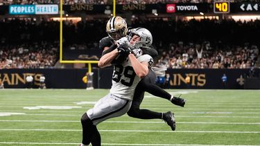 Brock Bowers (89), ala cerrada de los Raiders de Las Vegas, atrapa un pase de anotación con el safety Jonas Sanker, colgado, de los Saints de Nueva Orleans, intentando evitarlo durante la segunda mitad del juego de la NFL, el domingo 27 de septiembre de 2026, en Nueva Orleans. (AP Foto/Gerald Herbert)