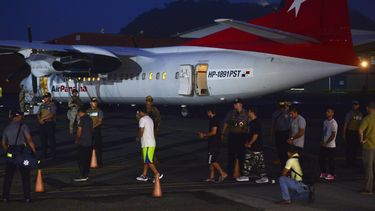 Migrantes colombianos caminan esposados y con grilletes hacia un avión para ser deportados en el aeropuerto Marcos A. Gelabert de Albrook en la Ciudad de Panamá, el martes 20 de agosto de 2024. (AP Foto/Agustín Herrera)