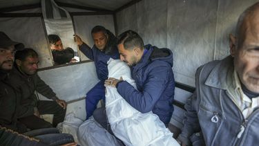 Mohammad Eid lleva el cuerpo de uno de sus tres familiares muertos el sábado en un ataque aéreo israelí mientras preparan el funeral en Deir al-Balah, centro de la Franja de Gaza, el domingo 12 de enero de 2025. (AP Foto/Abdel Kareem Hana)
