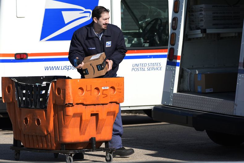 ARCHIVO - Un empleado del Servicio Postal de Estados Unidos carga paquetes ante una oficina de correos en Wheeling, Illinois, el 29 de enero de 2024. (AP Foto/Nam Y. Huh, Archivo)