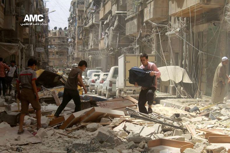 Foto sin fecha provista por Aleppo Media Center (AMC) donde se ven a unas personas caminando entre escombros luego de un bombardeo por parte de fuerzas del gobierno en Alepo, Siria. (Foto AP/Aleppo Media Center, AMC)