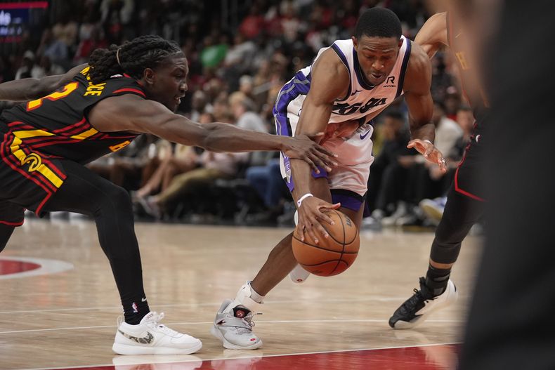 DeAaron Fox, de los Kings de Sacramento, trata de avanzar frente a Keaton Wallace, de los Hawks de Atlanta, en el encuentro del viernes 1 de noviembre de 2024 (AP Foto/ John Bazemore)